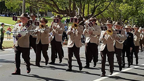 Harlaxton RSL Brass Band playing while marching down the street